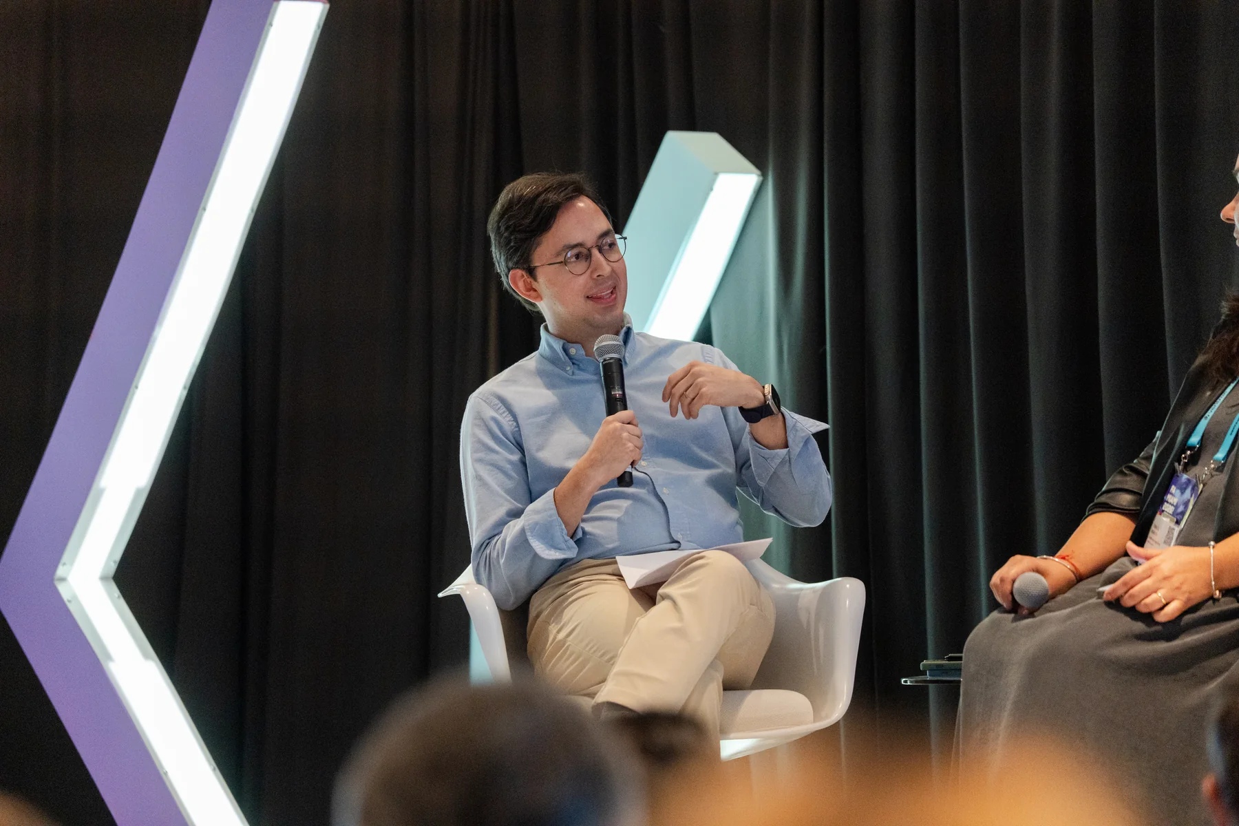 Panel speaker holding a microphone on a corporate stage