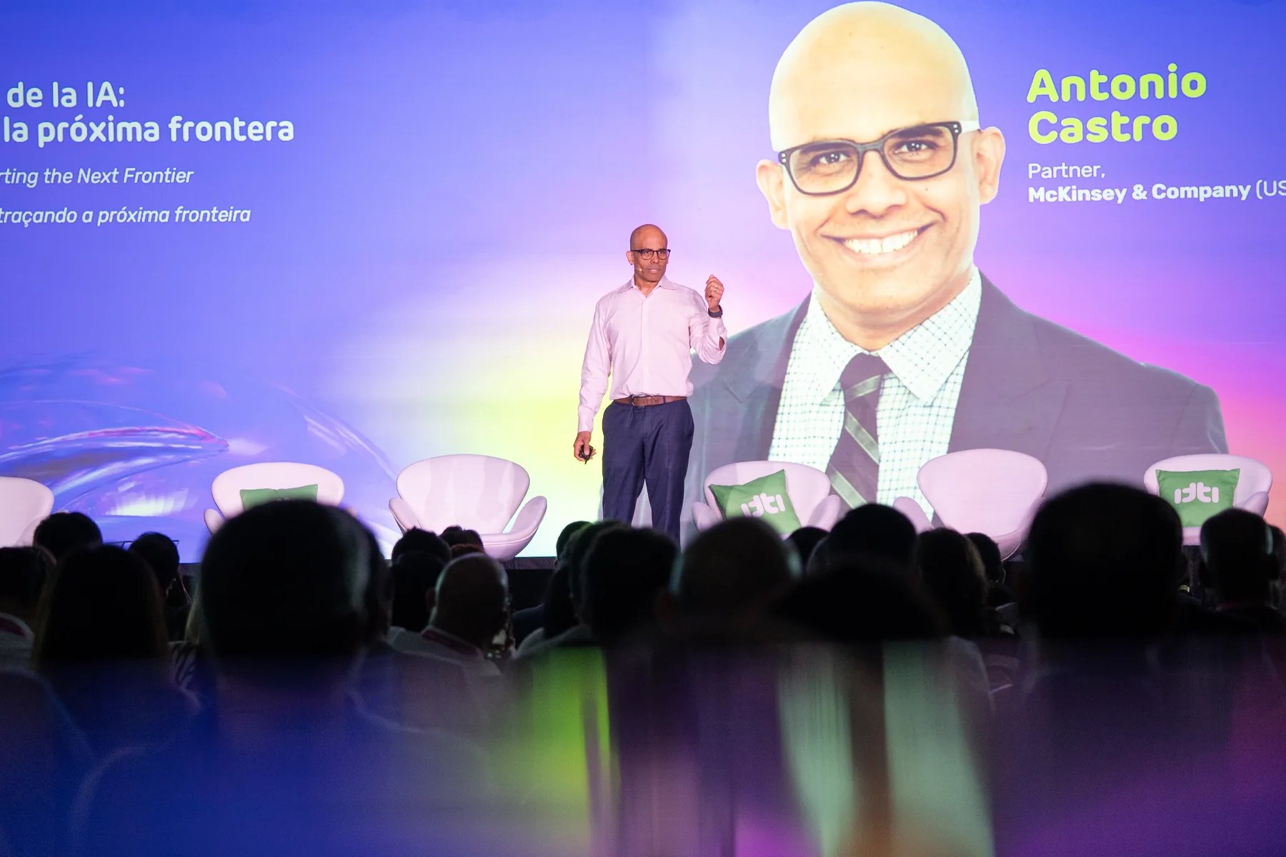 Speaker on stage with audience silhouettes in the foreground